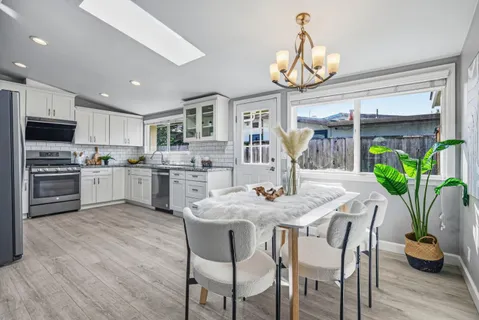 a kitchen with granite countertop kitchen island white cabinets and stainless steel appliances