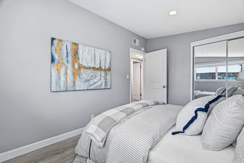 a bedroom with a bed and a painting on the wall