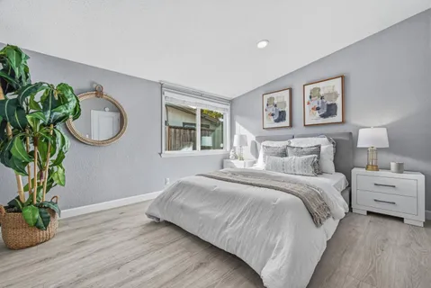 a bedroom with a bed and a potted plant