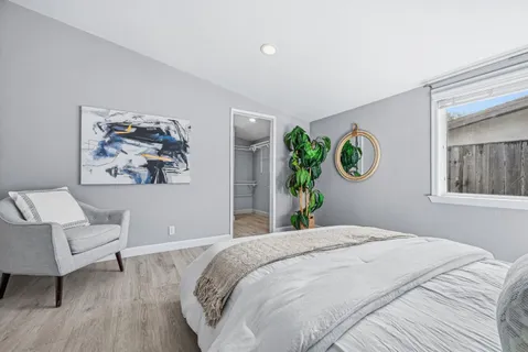 a bedroom with a large bed and a potted plant