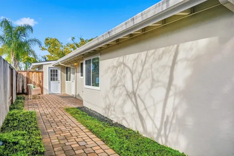a front view of a house with a yard and potted plants