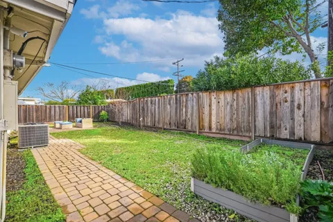 a view of a backyard with wooden fence