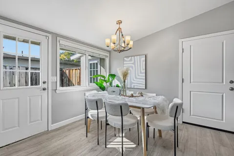 a view of a dining room with furniture a chandelier and wooden floor
