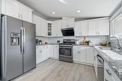 a kitchen with white cabinets and stainless steel appliances