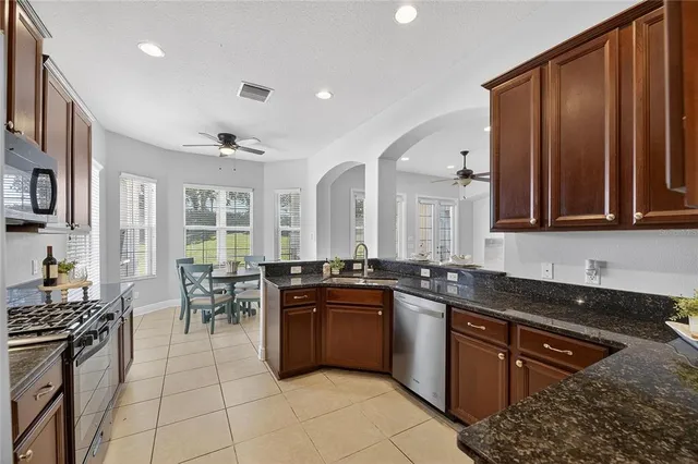 a view of an empty room with a chandelier fan