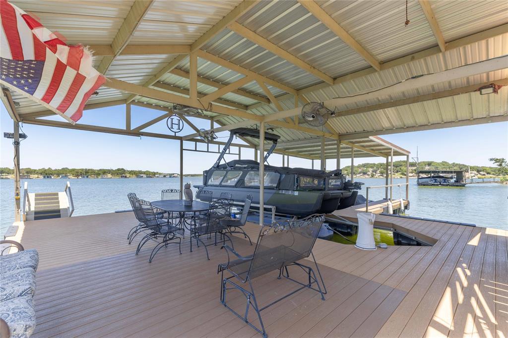 1005 Deep Water Road May, TX 76857 - Photo 34 of 40 Covered boat dock featuring a metal roof structure, composite decking, and direct water access with an integrated boat lift