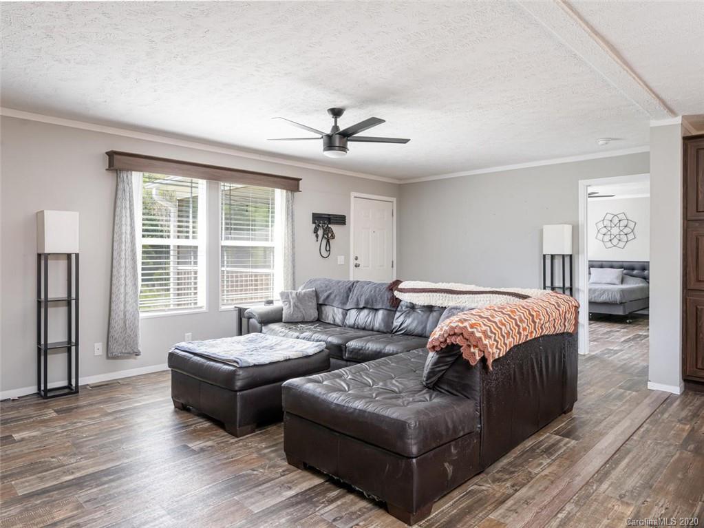 300 Lost Cove Road Clyde, NC 28721 - Photo 3 of 11 a spacious bedroom with bed and wooden floor