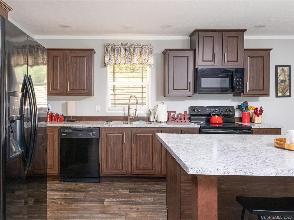 300 Lost Cove Road Clyde, NC 28721 - Photo 4 of 11 a kitchen with granite countertop a sink stove and refrigerator