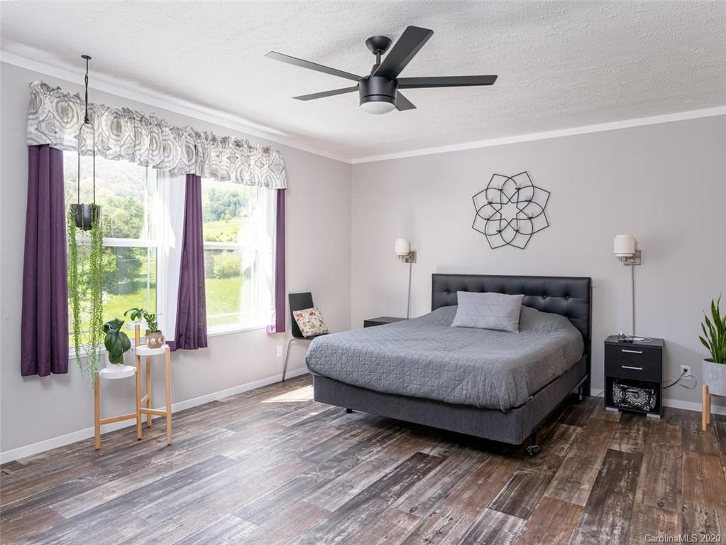 300 Lost Cove Road Clyde, NC 28721 - Photo 5 of 11 a bedroom with a bed and a large window