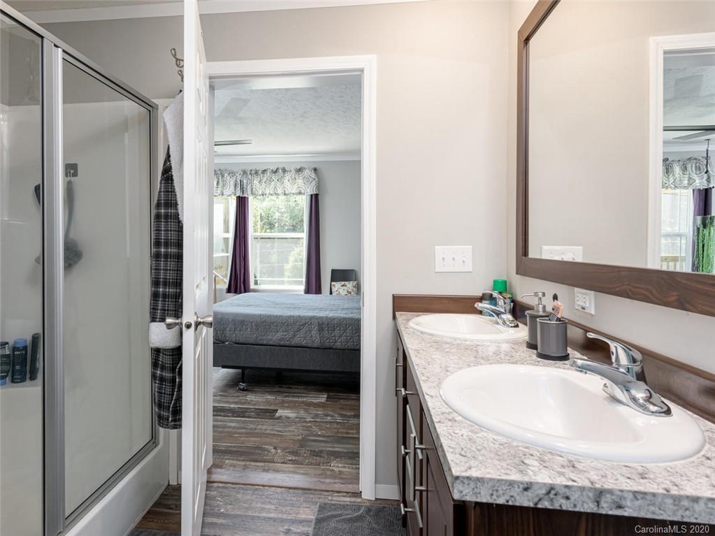 300 Lost Cove Road Clyde, NC 28721 - Photo 6 of 11 a en suite bathroom with a granite countertop sink and a mirror