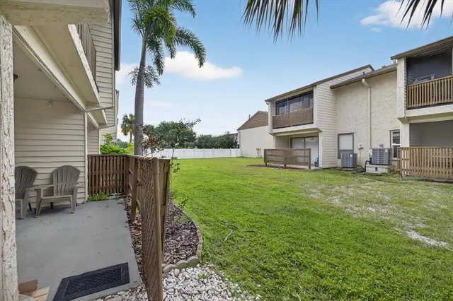a view of a house with backyard and a tree