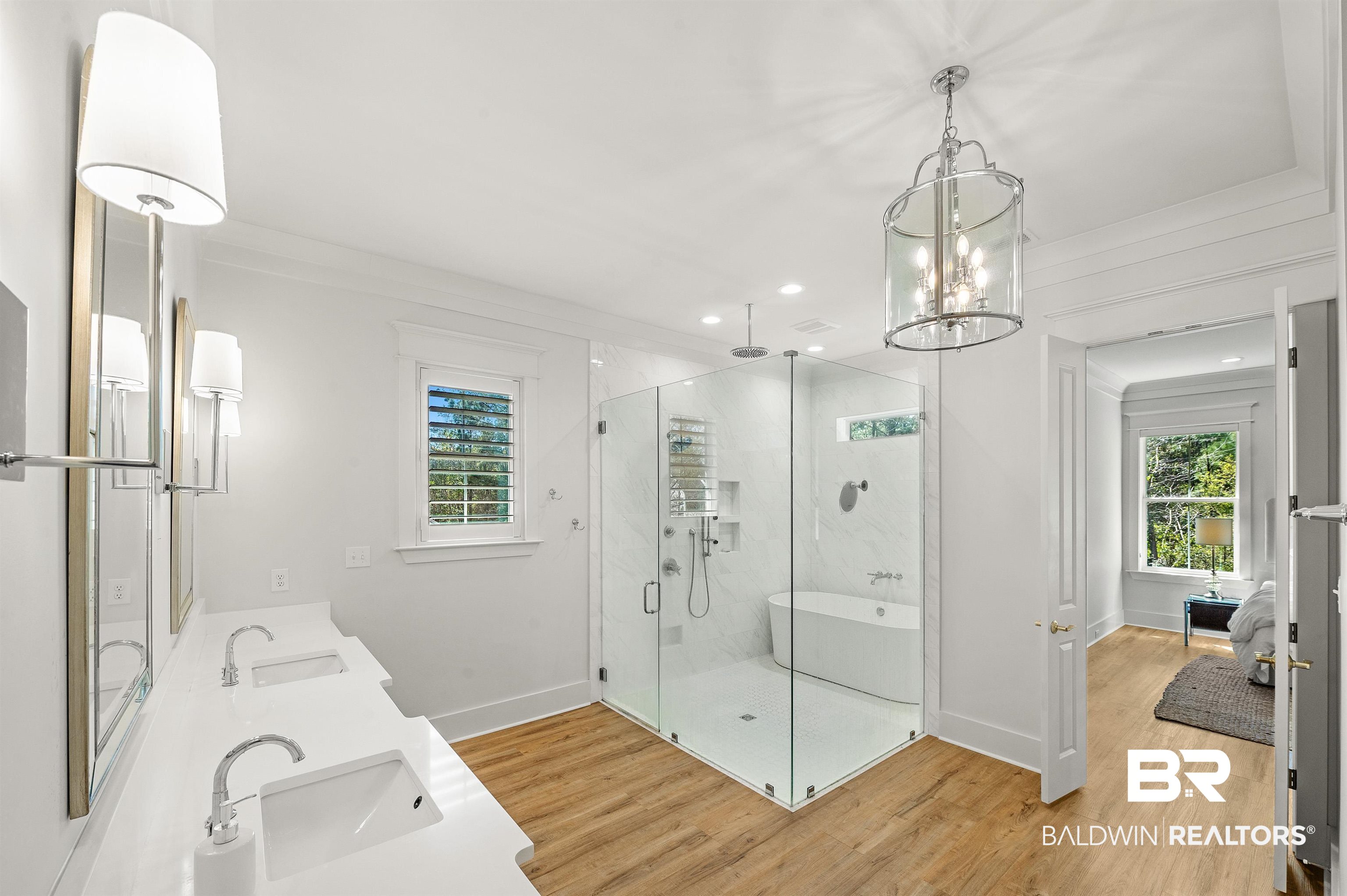 27888 Oakachoy Loop Daphne, AL 36526 - Photo 26 of 65 Full bathroom featuring a stall shower, a sink, a chandelier, wood finished floors, and baseboards