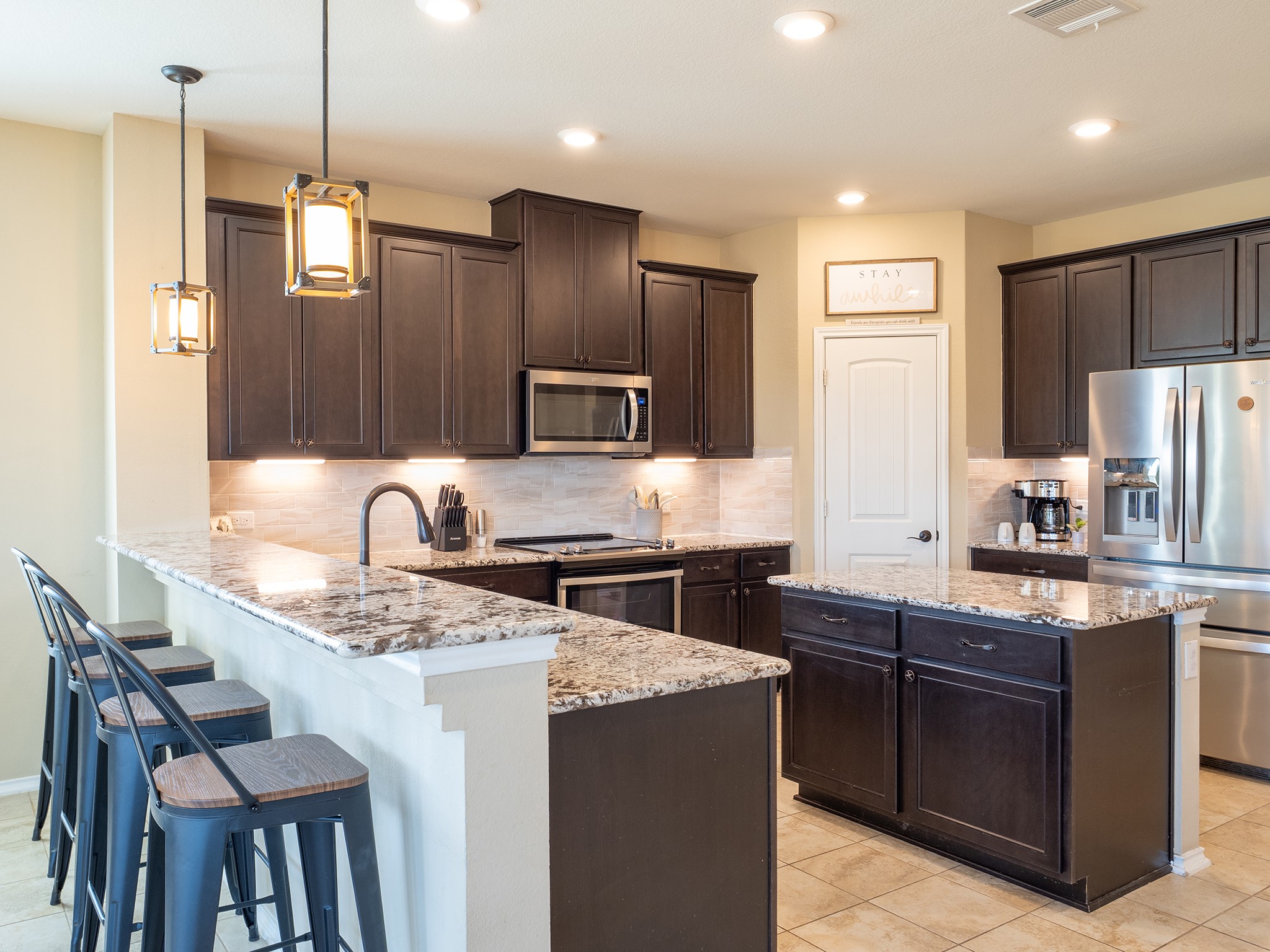 104 Rocroi Drive Georgetown, TX 78626 - Photo 9 of 40 Rich dark cabinetry pairs beautifully with expansive granite countertops in this modern kitchen.