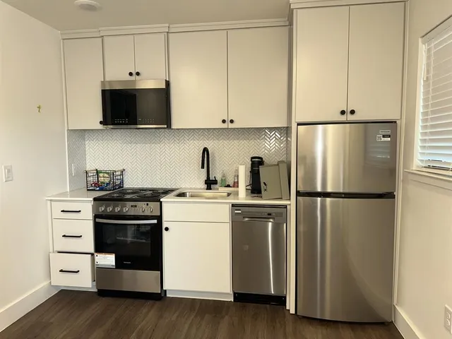 a kitchen with stainless steel appliances a refrigerator sink and cabinets