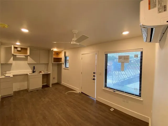 a large kitchen with a lot of cabinets and wooden floor