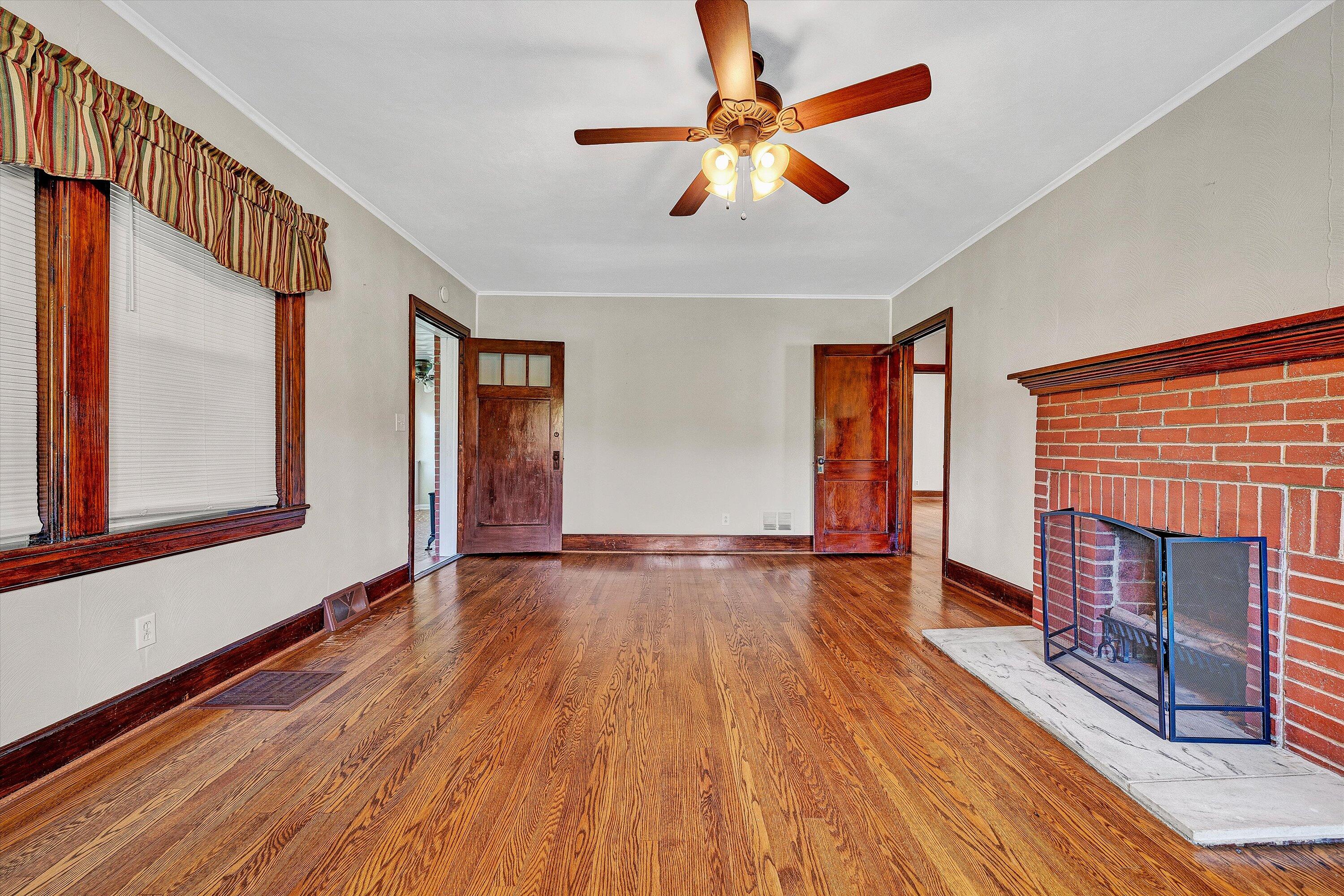 77 Mountain Pass Road Blue Ridge, VA 24064 - Photo 10 of 42 a view of an empty room with wooden floor fireplace and a window