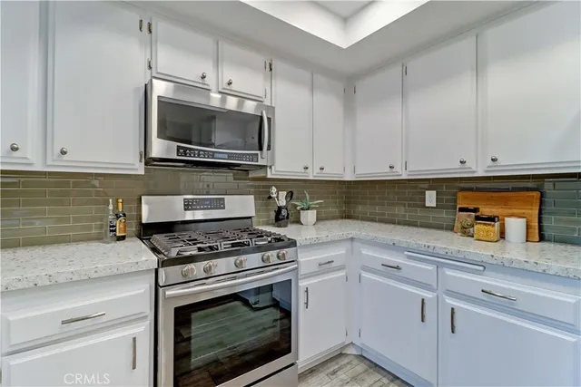 a kitchen with granite countertop a stove top oven a sink and a refrigerator
