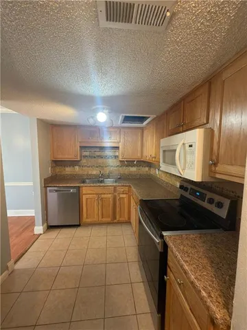 a kitchen with a stove a sink and a refrigerator