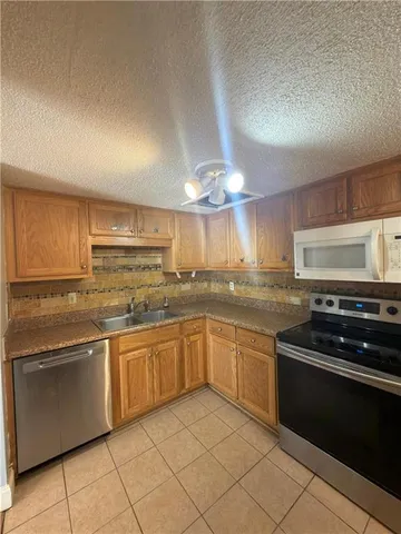 a kitchen with stainless steel appliances granite countertop a sink and cabinets