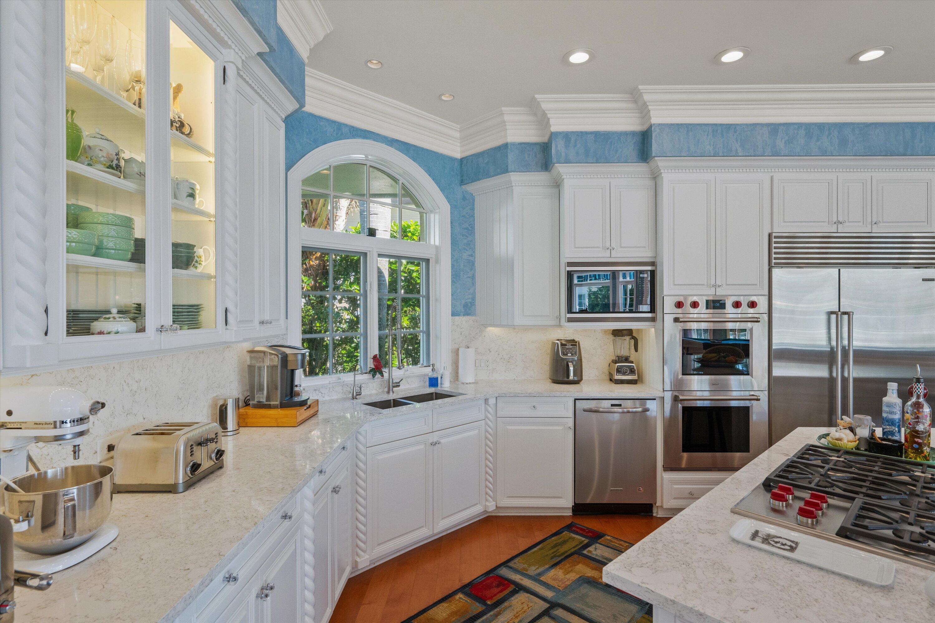 258 Locha Drive Jupiter, FL 33458 - Photo 19 of 76 a kitchen with stainless steel appliances kitchen island granite countertop a refrigerator oven a sink dishwasher and white cabinets with wooden floor