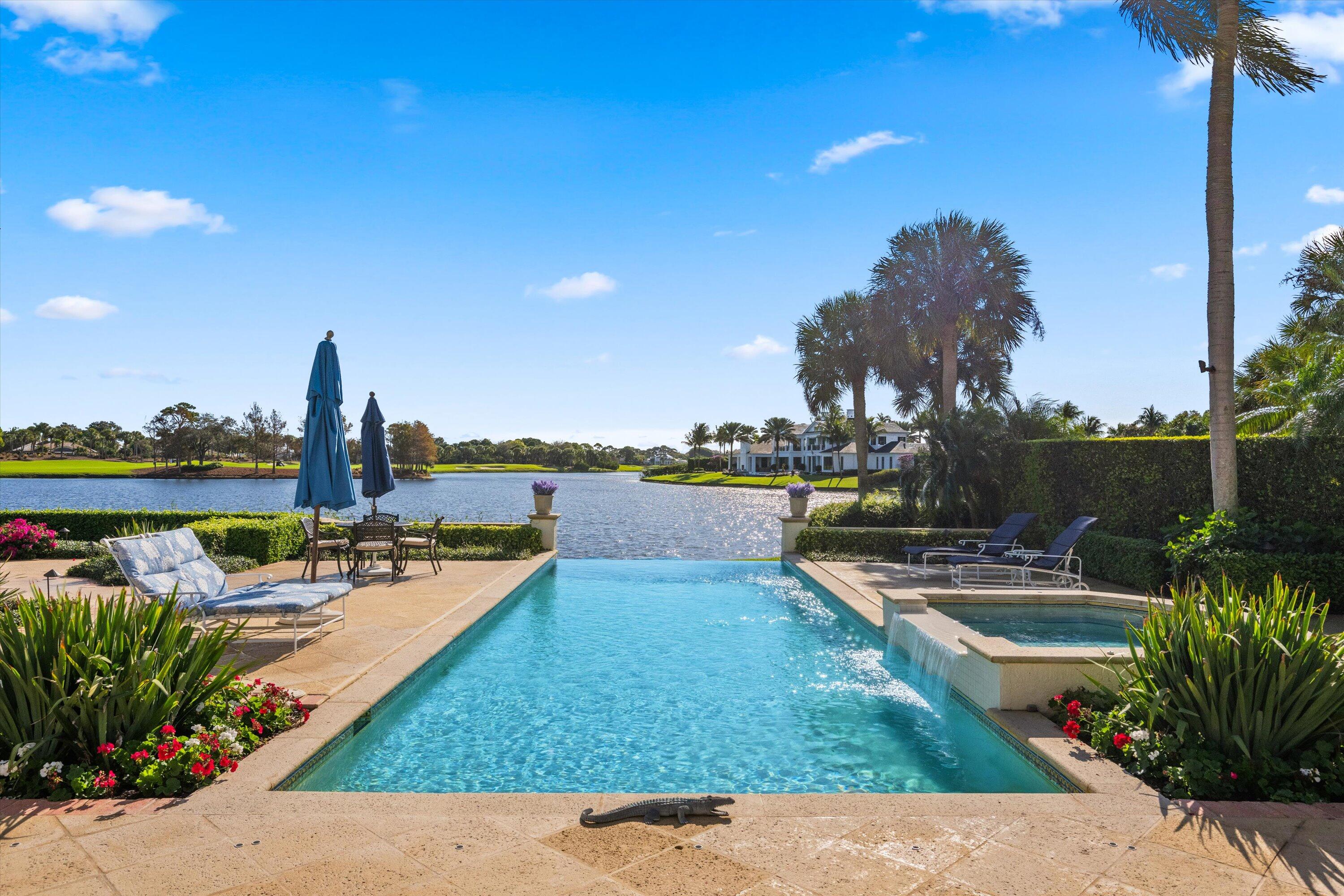 258 Locha Drive Jupiter, FL 33458 - Photo 61 of 76 a view of a lake with couches chairs and wooden fence