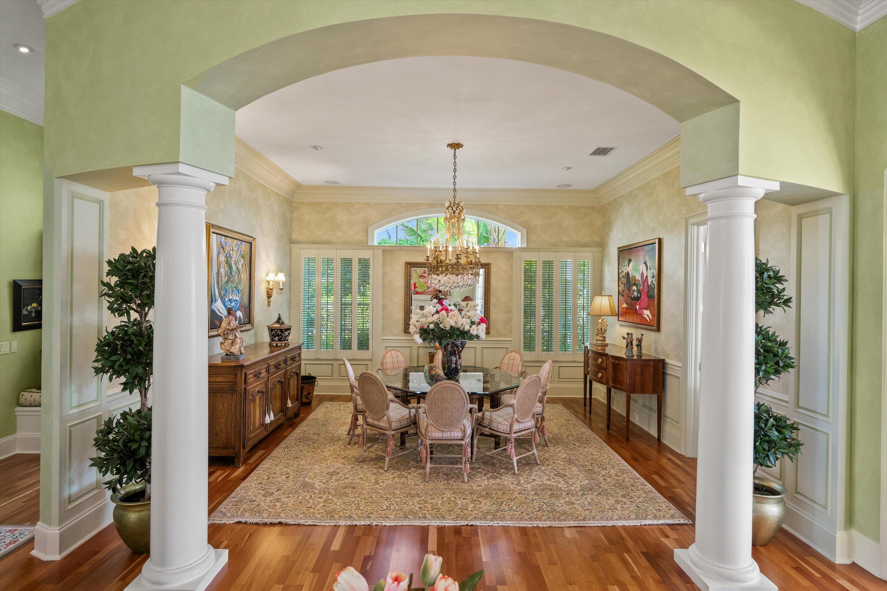 258 Locha Drive Jupiter, FL 33458 - Photo 10 of 76 a dining room with wooden floor a chandelier a wooden table and chairs
