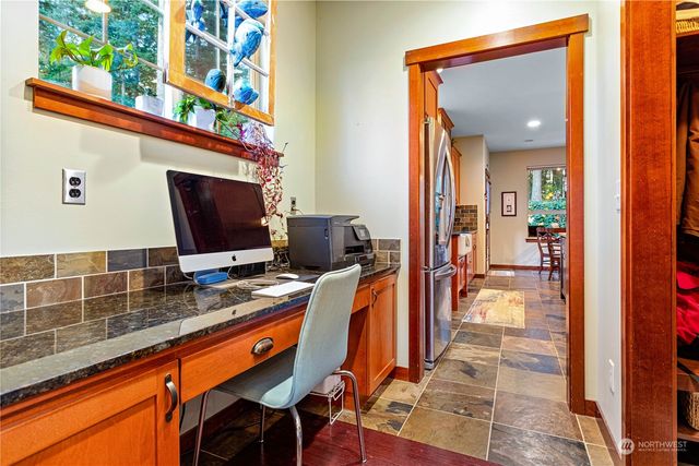 a view of a hallway with workspace and living room