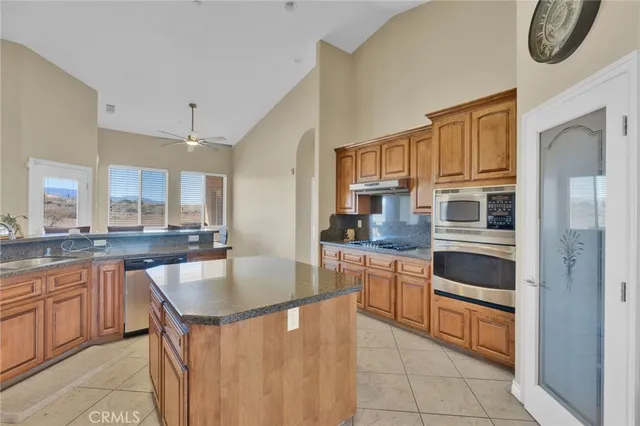 a spacious bedroom with a bed and a ceiling fan