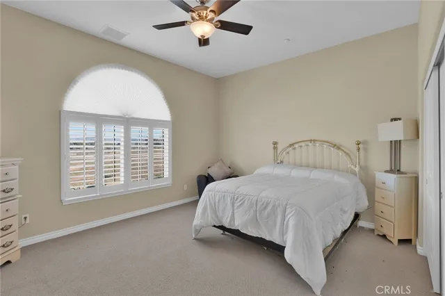 a bedroom with a bed and flat tv screen on the dresser