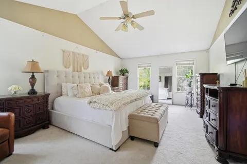 a bedroom with a large bed and a chandelier