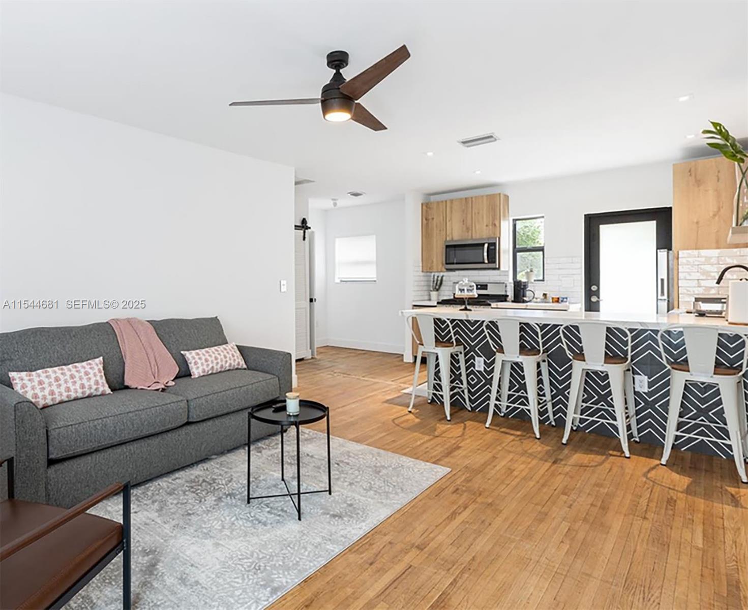 740 Southwest 9th Street, Unit 1 Miami, FL 33130 - Photo 2 of 34 a living room with furniture a ceiling fan and a rug