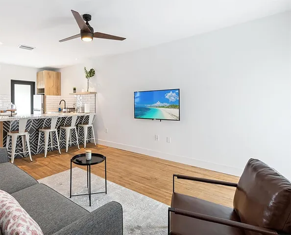 a living room with furniture and a view of kitchen