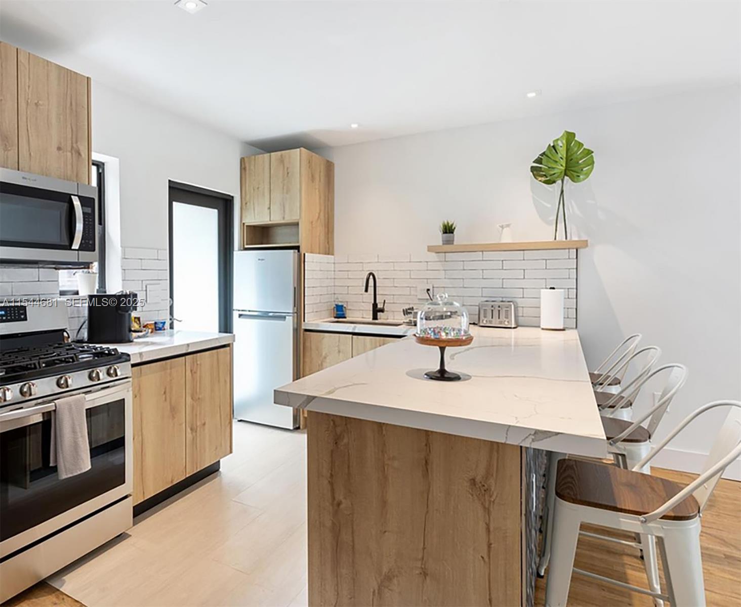 740 Southwest 9th Street, Unit 1 Miami, FL 33130 - Photo 4 of 34 a kitchen with kitchen island a sink stove and refrigerator