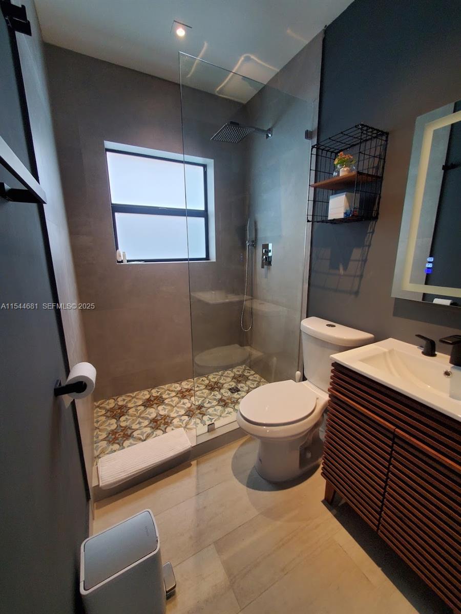 740 Southwest 9th Street, Unit 1 Miami, FL 33130 - Photo 10 of 34 a bathroom with a toilet sink and mirror