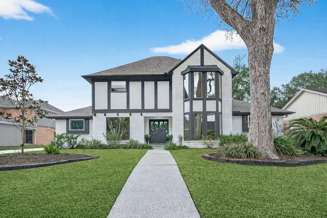 a front view of a house with a yard and potted plants