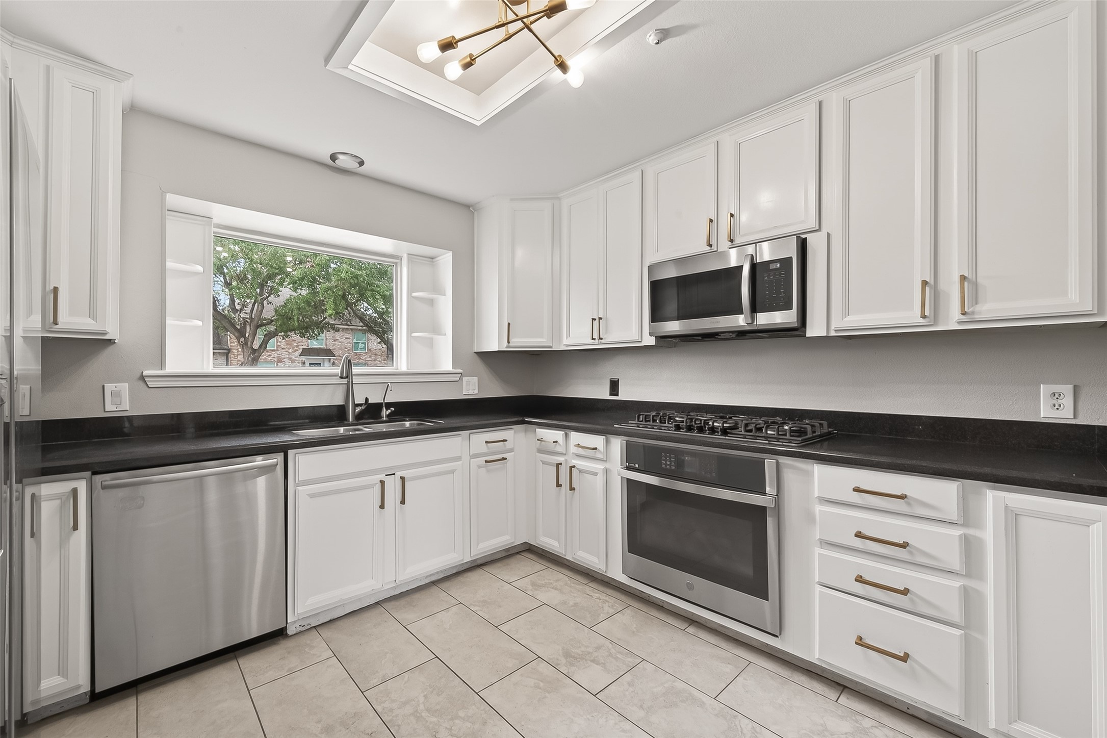 707 Montclair Boulevard Sugar Land, TX 77478 - Photo 9 of 50 a kitchen with granite countertop white cabinets stainless steel appliances and a window