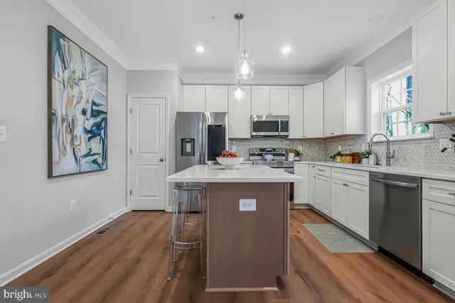 a kitchen with kitchen island wooden cabinets a stove a sink and a refrigerator