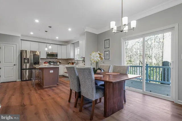 a dining room filled chandelier and wooden floor