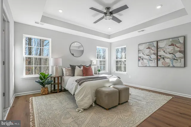 a bedroom with a large bed and wooden floor