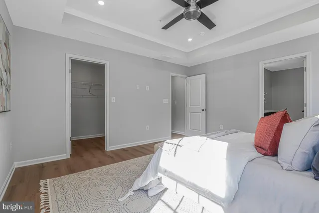 a living room with a bed furniture and a ceiling fan