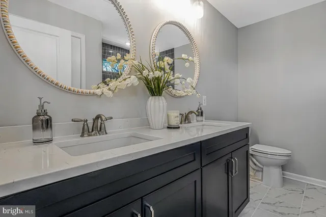 a bathroom with a sink a toilet and a mirror