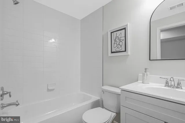 a bathroom with a granite countertop toilet sink and bathtub