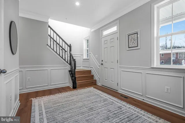 a view of entryway and hall with wooden floor