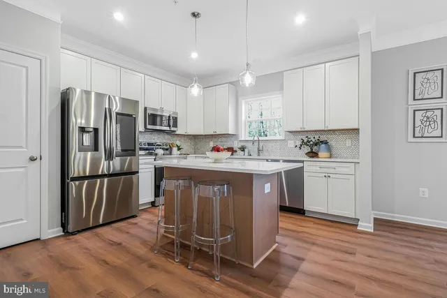 a kitchen with a refrigerator a sink and cabinets