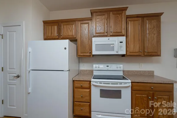 a kitchen with a stove a refrigerator and cabinets