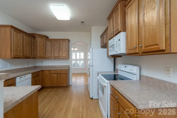 a kitchen with granite countertop a sink dishwasher stove and cabinets with wooden floor