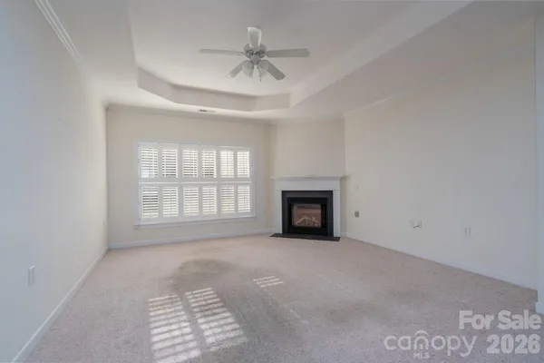 an empty room with windows and ceiling fan