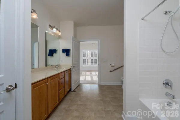 a spacious bathroom with a granite countertop sink a mirror and shower