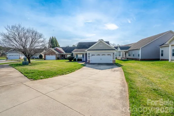a view of a house with a yard and large tree