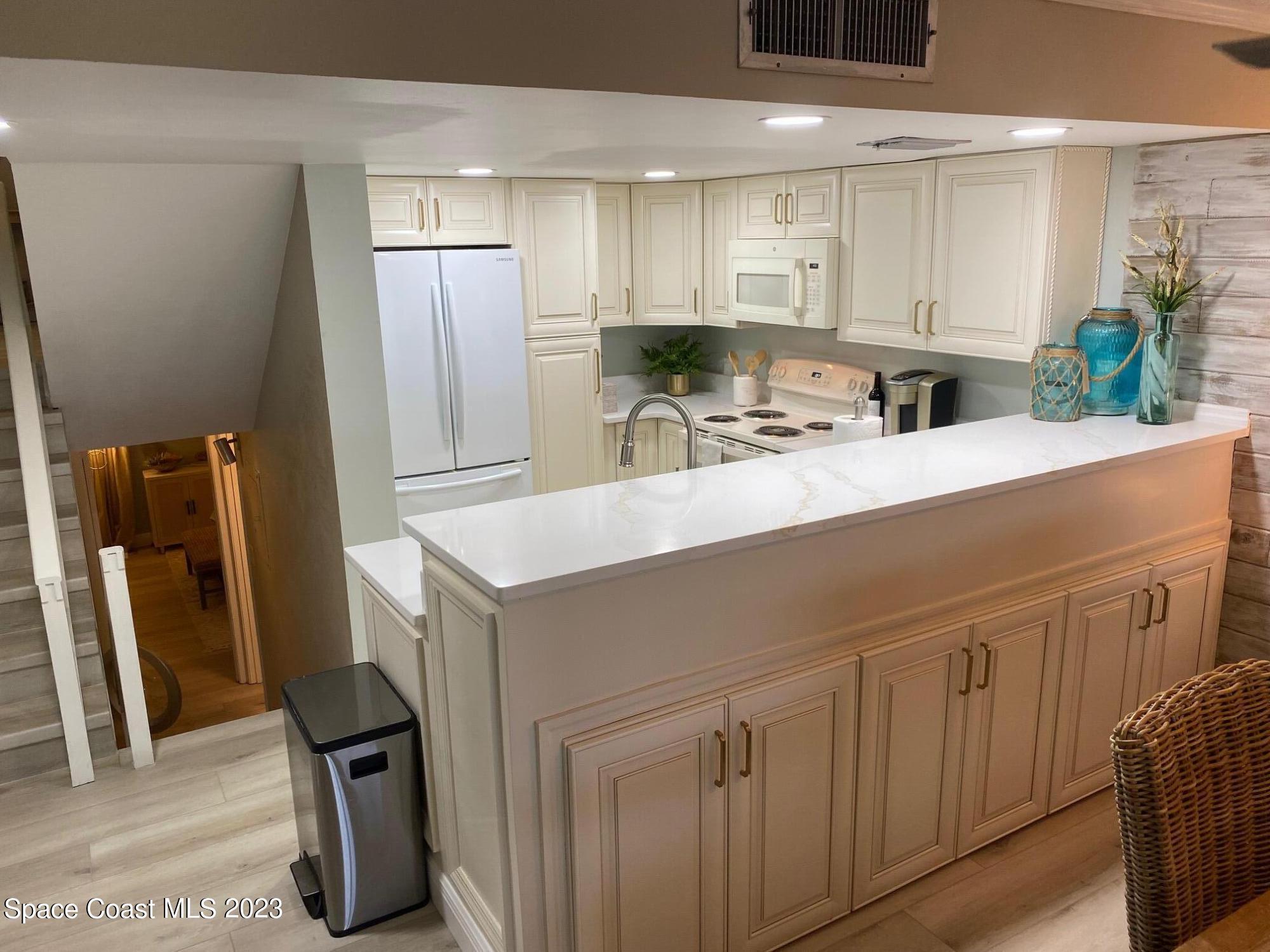 5050 Ocean Beach Boulevard, Unit 104 Cocoa Beach, FL 32931 - Photo 14 of 15 a kitchen with appliances a sink and cabinets
